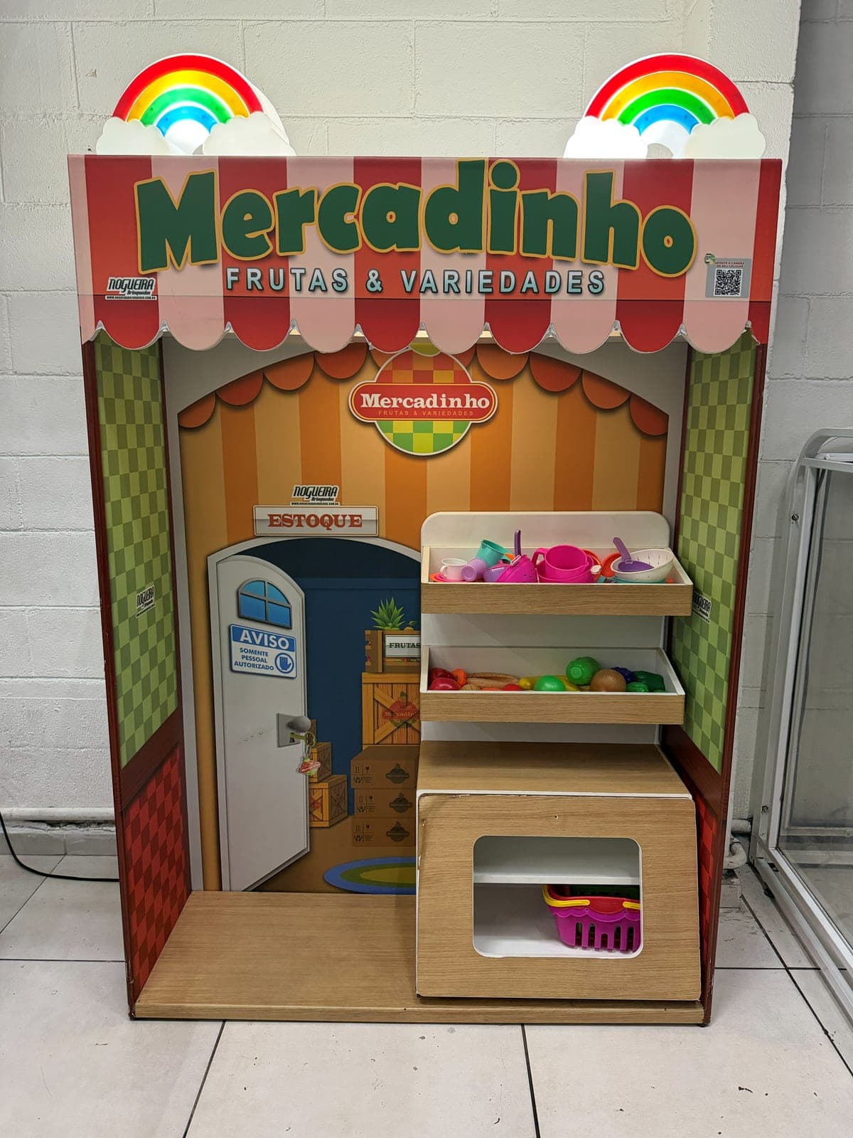 Mercadinho de brinquedo com prateleiras, frutas e utensílios coloridos